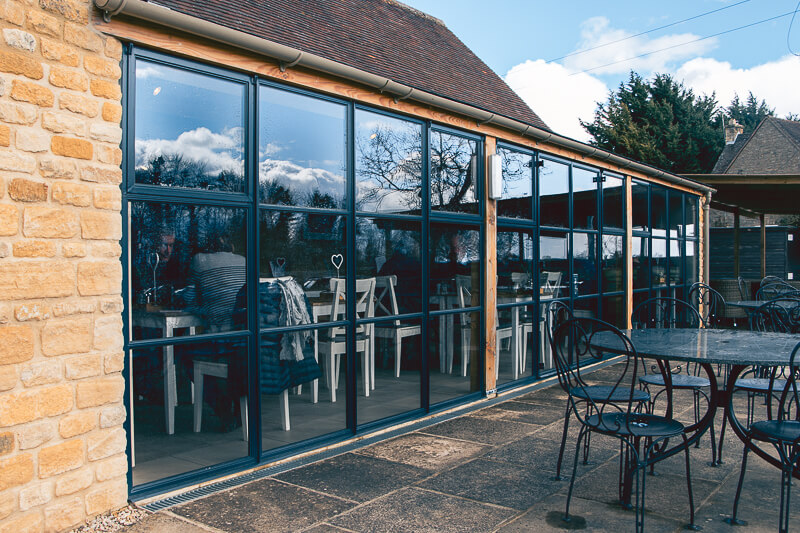 Traditional crittall windows were sourced for the feature and Douglas fir posts to stabilise the structure. For the walls we used a combination of reclaimed stone and two types of new stone to match the existing building.