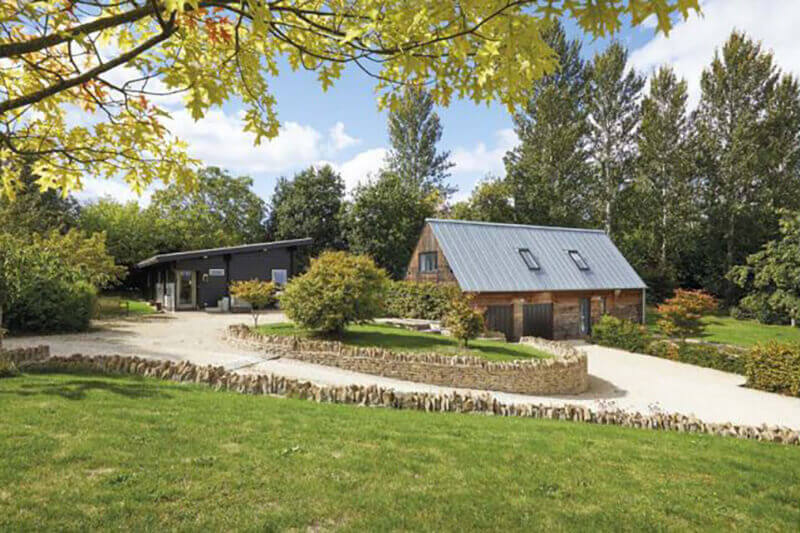 The two outbuildings were built after the main house, generating a potting shed and garages for the owner. The potting shed was created with a Scandinavian log cabin style outlook with a sedum roof. The garages were constructed with a Zinc roof and Scandinavian redwood cladding.