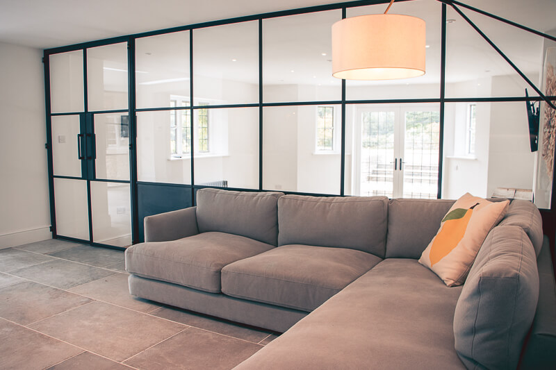 Black glazed casement windows installed create a natural separation to tv room and new doors out to the garden area.  